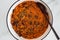 Vegan chilli sin carne with black beans and red lentils in spicy tomato sauce, healthy plant-based food