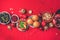Vegan Christmas appetizers, olive, orange, fruits, vegetable salads, candles, tangerine, pomegranate, star glitter sparkles on red