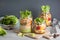 vegan couscous and pasta salad in mason jars with vegetables beans