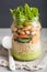 Vegan couscous salad in mason jar with beans cucumber carrot and