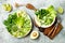 Vegan, detox Buddha bowl with avocado, zucchini noodles, green beans, spiralized cucumber, tomatoes, broccoli, lime and pesto