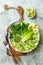 Vegan, detox Buddha bowl with avocado, zucchini noodles, green beans, spiralized cucumber, tomatoes, broccoli, lime and pesto