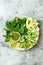 Vegan, detox Buddha bowl with avocado, zucchini noodles, green beans, spiralized cucumber, tomatoes, broccoli, lime and pesto