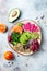 Vegan, detox Buddha bowl with quinoa, micro greens, avocado, blood orange, broccoli, watermelon radish, alfalfa seed sprouts.