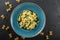 Vegan Farfalle pasta in a spinach sauce with broccoli, brussels sprouts, green beans in plate on dark stone background