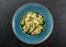 Vegan Farfalle pasta in a spinach sauce with broccoli, brussels sprouts, green beans in plate on dark stone background