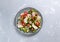 Vegan fattoush salad in a plate on a gray background.