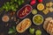 Vegan food background. Vegetarian snacks: hummus, beetroot hummus, green peas dip, vegetables. Top view, dark background, copy sp