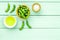 Vegan food with green soybeans or edamame and oil on mint green wooden background top view copy space