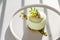 Vegan gluten free low calorie dessert. Round Pistachio mousse cake decorated with fresh pistachio greens, matcha on light