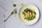Vegan healthy food grilled eryngii mushroom salad with cilantro peanuts lemon in bowl on white slate table