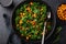 Vegan kale and roasted chickpeas salad in black bowl