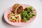 Vegan Meal On Plate With Savoury Roll Filled With Chickpea Lentil And Mushroom Next To Couscous And Salad On White Background