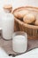 vegan milk substitution, potato milk in a glass and potatoes in basket, vertical shot. vegetarian drink