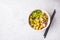 Vegan poke bowl with pickled tofu, vegetables and rice in a white bowl, top view