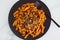 Vegan red pesto fusilli pasta with marinated tofu topping, healthy plant-based food