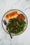 Vegan roasted pumpkin and kale salad with shredded teriyaki tofu and garlic bread, healthy plant-based food