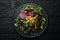 Vegan salad: beets, arugula and chickpeas on a black stone plate. Healthy diet food. Top view.