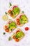 Vegan sandwiches with avocado, watermelon radish and tomatoes on a white background