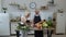 Vegan senior couple cooking salad with raw vegetables. Looking on digital tablet for online recipe