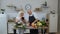 Vegan senior couple cooking salad with raw vegetables. Looking on digital tablet for online recipe