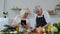 Vegan senior grandparents looking for a culinary recipe online on digital tablet, cooking salad