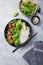 Vegan teryaki  tempeh or tempe buddha bowl  with rice, steamed broccoli, spinach  and lime on gray background. Healthy food