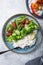 Vegan teryaki  tempeh or tempe buddha bowls  with rice, steamed broccoli, spinach  and lime on black  background. Healthy food