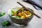 Vegan tofu poke bowl with rice, cucumber, avocado and nori, gray background