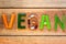 Vegan word with wooden background