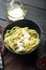 Vegan Zoodles with green pesto, in bowl, on black wooden table background