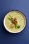 Vegaterian winter split pea turmeric soup on dark blue background, close-up, top view, vertical