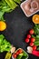 Vegearian lunch. Vegetables tomato, cucumber, asparagus, salad, orange on black background top view copyspace
