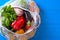 Vegetable basket, pepper, eggplant, spinach in white eco bag on blue background, food delivery, copy space