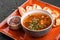 Vegetable bean soup with herbs in bowl with croutons on dark stone background. Healthy vegan food. Top view