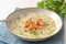 Vegetable cream soup from parsley and potatoes served with salmon strip garnish in a plate on a blue napkin, selected focus