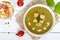 Vegetable cream soup with spinach and potatoes in a white bowl with garlic croutons on a dark wooden background.