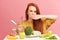 Vegetable diet. Sad dull woman holding broccoli on fork while making grimace