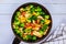 Vegetable dish stir fry with chicken in pan on white surface