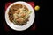 Vegetable fried rice & chili chicken on white plate isolated on black background. Delicious food. Popular Indo-Chinese dish.