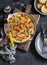 Vegetable frittata in a cast iron skillet on wooden background. Delicious brunch