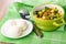 Vegetable mix from green bean, green peas, potato, onion, carrot in bowl, knife, fork, boiled eggs in saucer on napkin on table