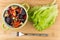 Vegetable mix in green bowl, lettuce and fork on table