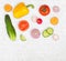 Vegetable mix on white wooden isolated background. Fresh yellow pepper, chopped tomatoes, onion, cucumber slice, carrot, radish.