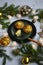 Vegetable muffin on a green plate, snowflakes, gilded cones, fir branches, garland on a light wooden background