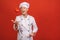 Vegetable Recipes. Excited senior Chef Man Juggling Throwing Sweet Pepper Standing In Studio Over red Background
