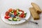 Vegetable salad with cheese mozzarella, fork in plate, bread