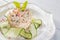 Vegetable salad with meat, herbs, cucumber and spices on white plate