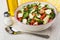 Vegetable salad with mozzarella in bowl, vegetable oil, salt, sp