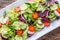 Vegetable salad. Plate of salad with vegetables on rustic oak table. Assortment of ingredients of vegetable salad